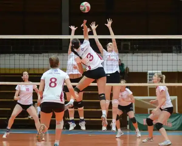 girls playing volleyball on court